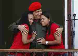 Chavez hugs his daughters on the balcony of Miraflores Palace in Caracas, July 4, 2011 (Reuters)
