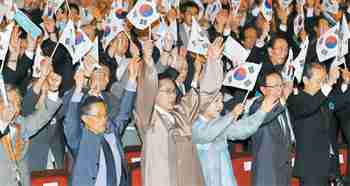 Lee Myung-bak and first lady, Kim Yoon-ok (center) wave Korean flags on Liberation Day (Yonhap)