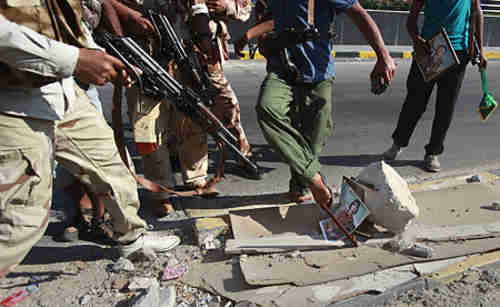 Libyan rebel fighters step on a picture of Muammar Gaddafi in Tripoli (Reuters)