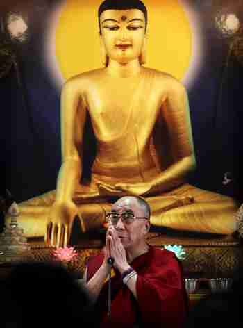 Dalai Lama under a portrait of Buddha (AP)