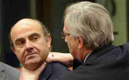 Chairman Jean-Claude Juncker of the eurozone finance managers, right, puts his hands on the neck of Spain's Economy Minister Luis de Guindos during a meeting of eurozone finance ministers at which Spain was given more wiggle room in cutting its big deficit.