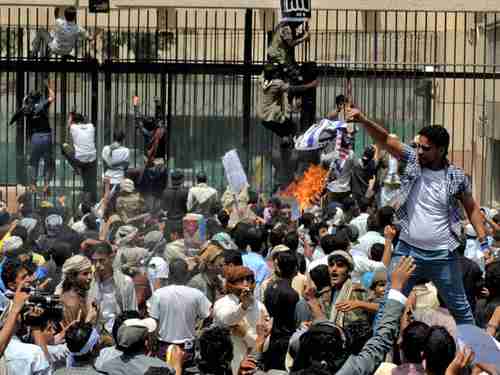 In Sanaa Yemen, a protester burns a mock American Flag as protesters storm the U.S. embassy. (EPA)