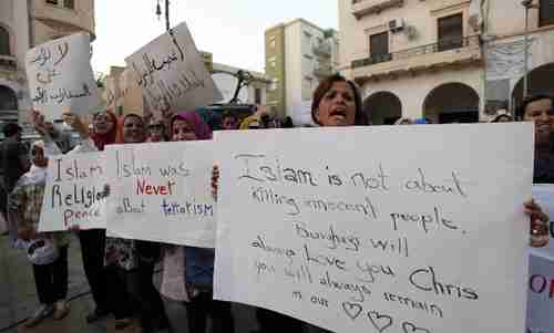 Libyans hold signs on Friday to express sympathy for Americans killed (AP)