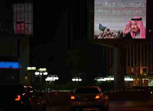 A patriotic billboard in Riyadh features an image of soldiers and a portrait of Saudi King Salman (AFP)