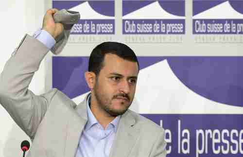 Hamza al-Houthi throws back a shoe thrown at him on Thursday (AFP)