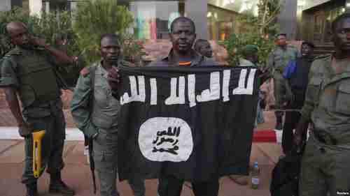 Mali security officers show a jihadist flag that belonged to the hotel attackers (Reuters)
