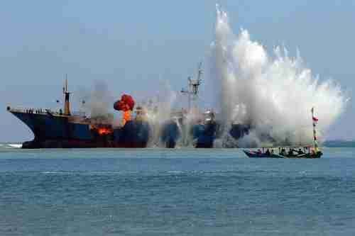 Indonesians blow up a foreign fishing boat caught illegally fishing in Indonesian waters (EPA)