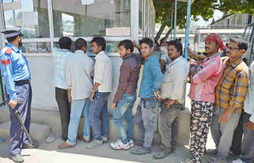 Saudi migrant workers at a bus stop in Kashmir on Wednesday (AFP)