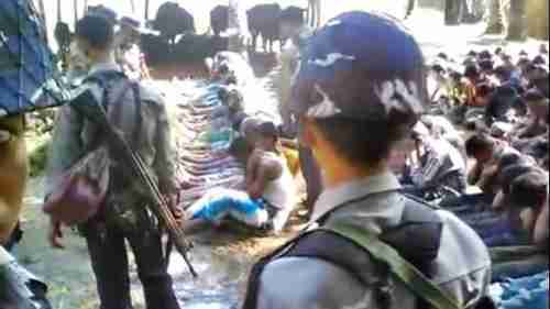 Screen grab from video. Dozens of Rohingyas on the right are being forced to watch the beating