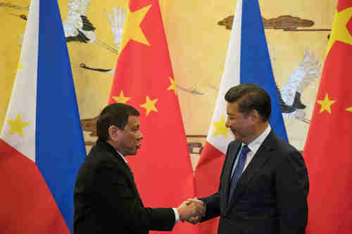 Rodrigo Duterte and Xi Jinping share a warm greeting and handshake (Reuters)