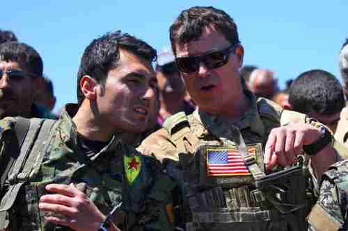 A US officer speaking with a YPG fighter on April 25 (AFP)