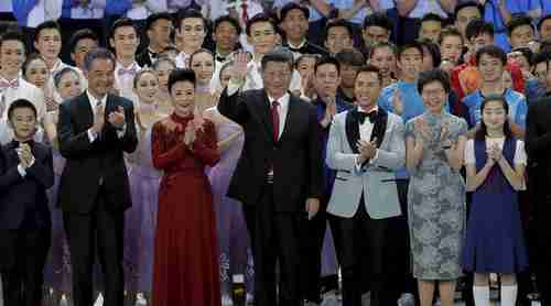 China's president Xi Jinping (center) and his wife in Hong Kong on Friday, surrounded by Hong Kong officials (AP)