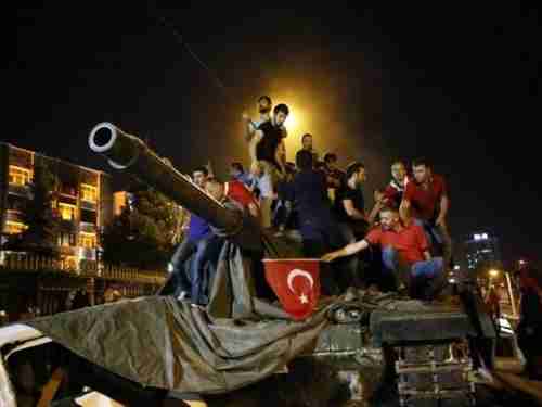 Young men stand on a Turkish army tank in Ankara on July 16, 2016, the day after the attempted coup. (Reuters)