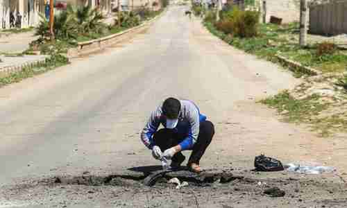  A Syrian man collects samples from the site of the Sarin gas attack in Khan Sheikhoun in April. (AFP)