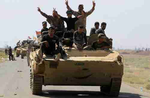 Iraqi forces flash victory sign after defeating ISIS in Hawija (AFP)