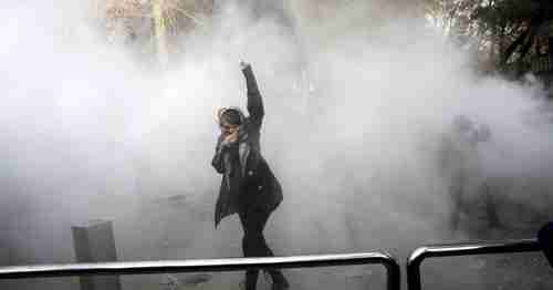 A university student protects herself from teargas while protesting at the University of Tehran. (AP)
