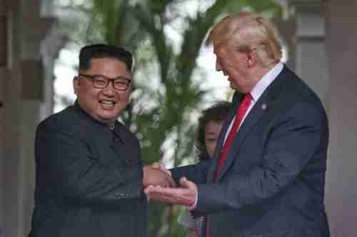Kim Jong-un and Donald Trump shake hands in Singapore on Tuesday (AP)