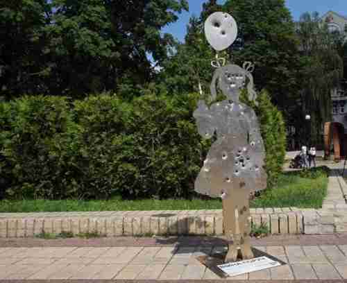 In Kiev, a metal silhouette of a girl with a balloon, dotted with bullet holes, a reminder of the war in Donbas. (Getty)