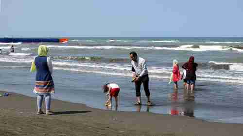 An Iranian family frolicking at the beach in the Caspian Sea port city of Gisum (Getty)