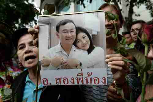 Supporters hold a picture of Thaksin Shinawatra and his sister Yingluck in Bangkok on Aug 5, 2017. (AFP)