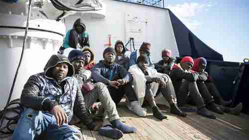 Migrants sit on the deck of the Sea Eye rescue ship in the Mediterranean Sea (AP)