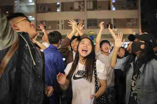 Pro-democracy supporters celebrate huge gains in the district council elections (AP)