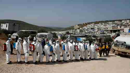 White Helmets (Syrian Civil Defense) prepare to disinfect refugee camp in northern Idlib, on border with Turkey (Getty)