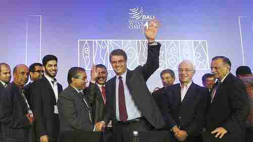 World Trade Organization president Roberto Azevedo (center) joins the other delegates in cheering their 'historic' agreement on Saturday in Bali