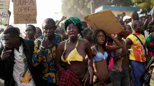 Women protesting Chadian troops bear their chests in a traditional sign of placing a curse on Monday (AP)