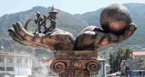 'The Statue of Tolerance' in Antakya, the provincial capital of Turkey's Hatay province.  Two massive hands are raised towards the sky, one holding a globe, the other a cross, a crescent and a Star of David