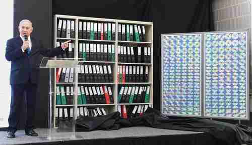 Israel's prime minister Benjamin Netanyahu stands next to a facsimile of the intelligence archive that Mossad had taken from a Tehran warehouse in January (Times of Israel)