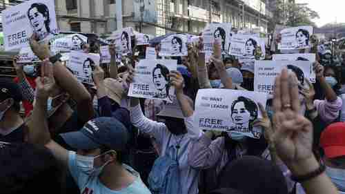 Thousands of protesters in Yangon on Sunday carrying placards with image of Aung San Suu Kyi (BBC)