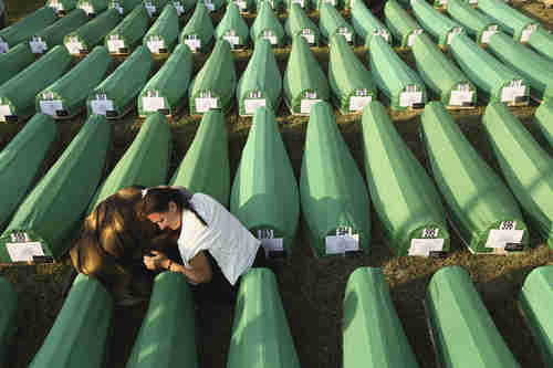 Two young women on Saturday mourn over one of 613 coffins of Srebrenica massacre (Getty)