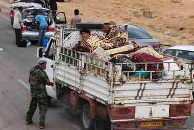 Civilians fleeing Sirte pass a checkpoint on the outskirts of the city on Sunday. (Reuters)