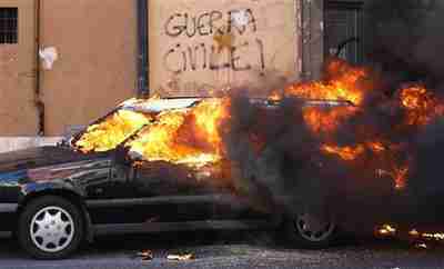 A car burns next to a wall with graffiti reading 'Civil War' on Saturday in Rome (Reuters)