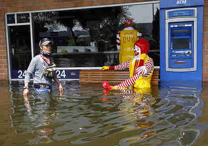 A Thai resident wades past Ronald McDonald in Bangkok (EPA)
