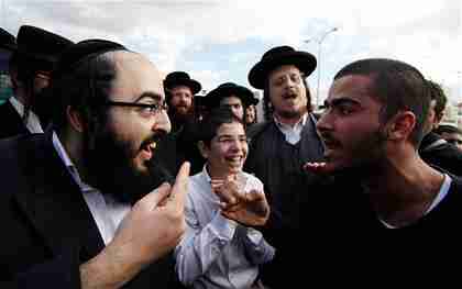 An ultra-Orthodox Jewish man argues with a secular man during the protests (Reuters)
