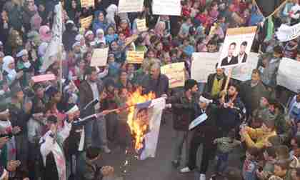 Anti-government protesters burn an image of President Bashar al-Assad during a demonstration in Homs. (Reuters)