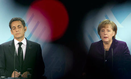 Nicolas Sarkozy and Angela Merkel at a press conference on Monday (AP)