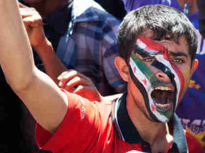 Anti-government protester in Yemen with the colors of the national flags of Yemen and Syria on his face (Reuters)