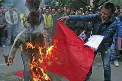 Tibetan exiles burn a Chinese flag and an effigy representing a Chinese official during a protest in New Delhi, January 17, 2012 (Reuters)