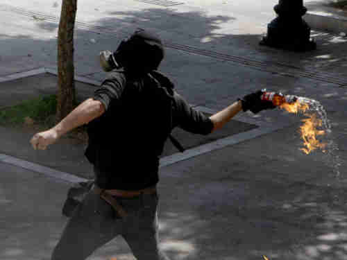 Protester throws petrol bomb at police (Reuters)