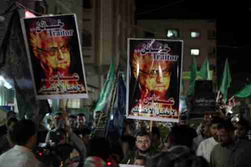 Hamas supporters carry signs calling Abbas a 'traitor'