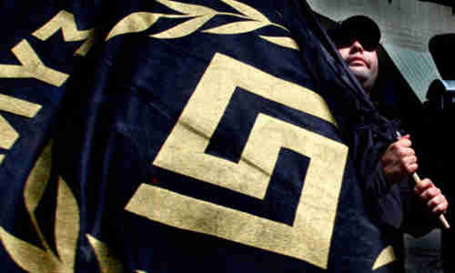 The Golden Dawn symbol appears on a flag held by a party member (Reuters)