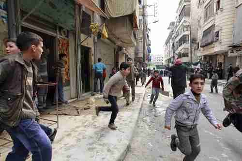 People run after hearing a missile strike in Aleppo on Friday (Reuters)