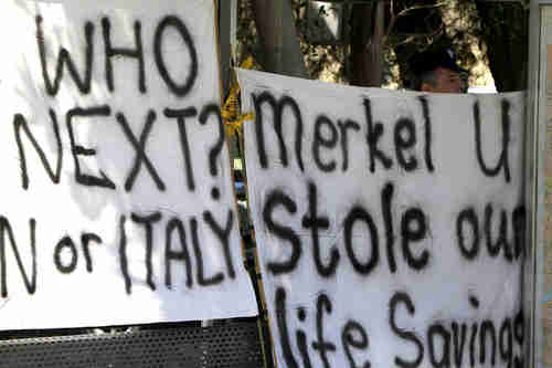 Protesters holds up protest signs in Nicosia, Cyprus (AP)