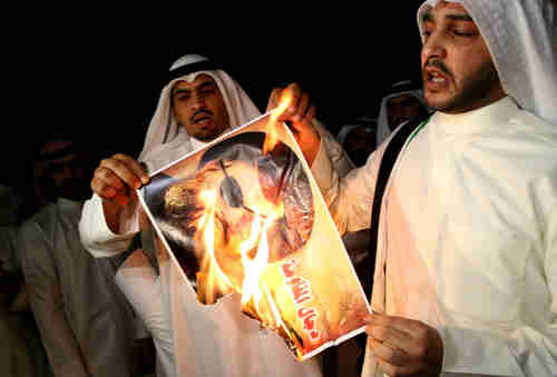 Kuwaiti protesters burn a picture of Hezbollah leader Hassan Nasrallah (AFP)