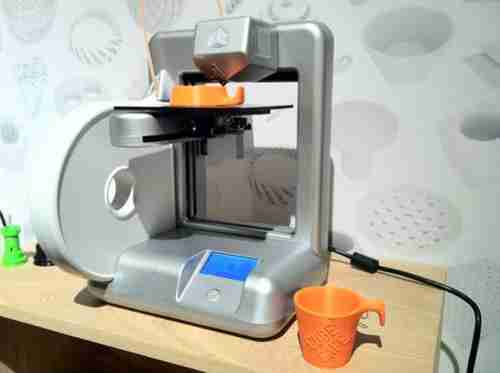 3D printer printing a cup -- it could just as easily have been a gun