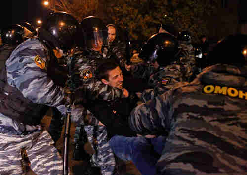 Moscow police detain a man on Sunday (Reuters)