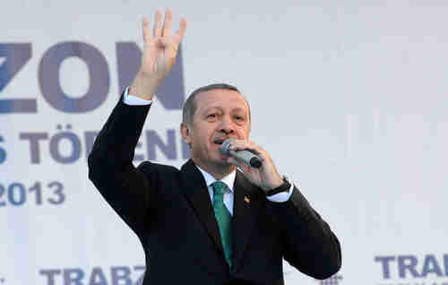 Erdogan on Saturday gives the four-finger salute used by Muslim Brotherhood supporters (AFP)